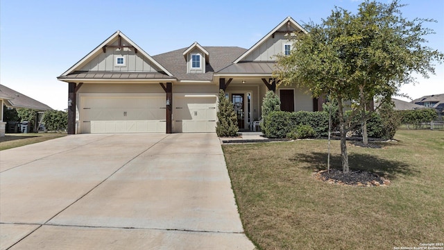 craftsman-style house featuring a front yard, driveway, a standing seam roof, board and batten siding, and metal roof