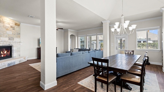 dining room featuring a stone fireplace, dark wood-type flooring, baseboards, and visible vents