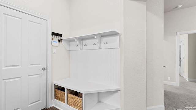 mudroom with baseboards and carpet floors