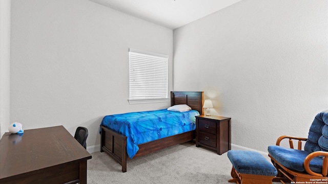 bedroom with baseboards and light carpet