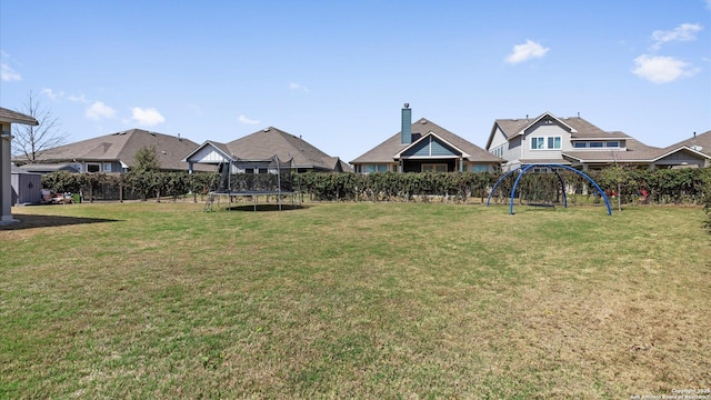 view of yard with a playground, a trampoline, and fence