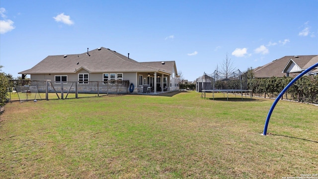 view of yard featuring a trampoline and fence