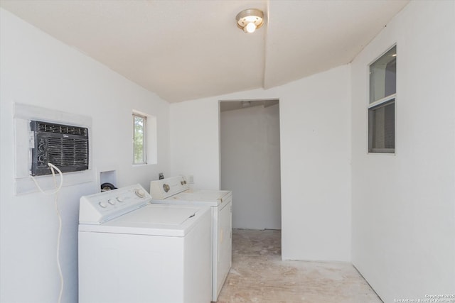 washroom with laundry area, washing machine and dryer, and a wall mounted air conditioner