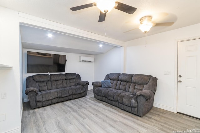 living area featuring a wall mounted air conditioner, baseboards, and wood finished floors