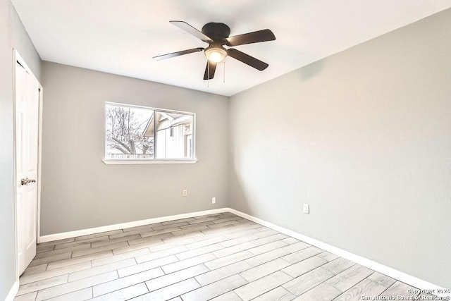 empty room featuring baseboards, wood finished floors, and a ceiling fan