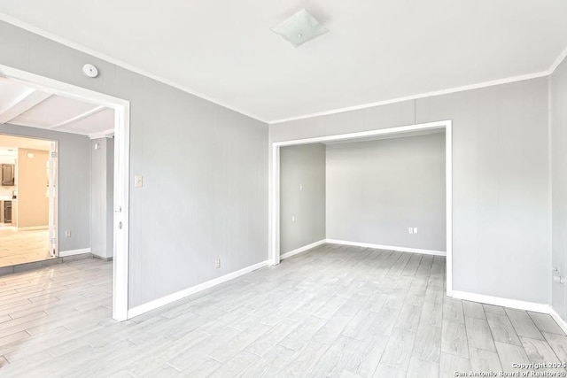 unfurnished room featuring baseboards, wood finished floors, and crown molding