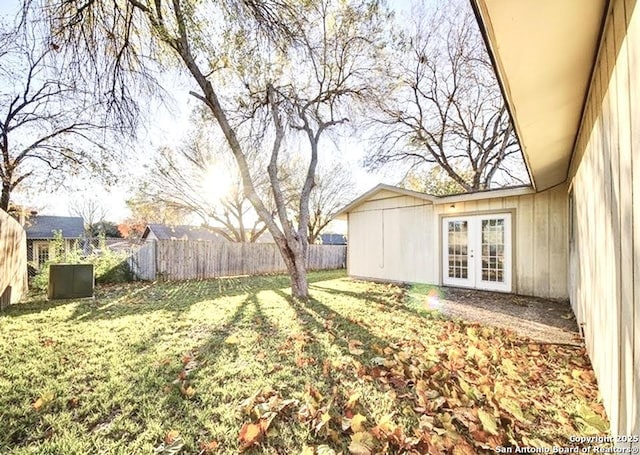 view of yard with french doors and a fenced backyard