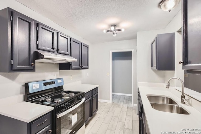 kitchen featuring under cabinet range hood, a sink, a textured ceiling, stainless steel range with electric cooktop, and light countertops