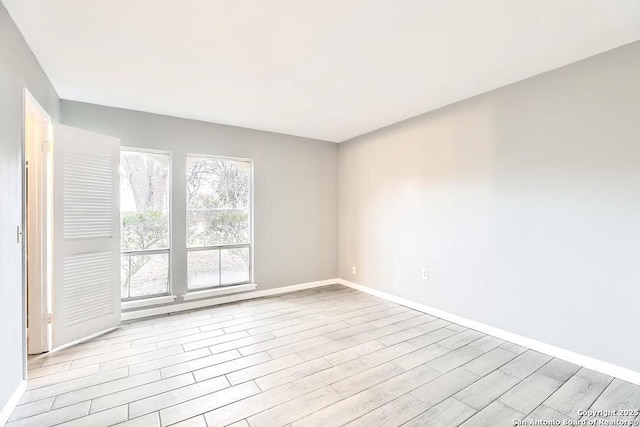 spare room with wood finished floors and baseboards