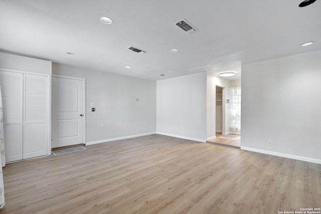 spare room featuring visible vents, baseboards, and light wood-style flooring