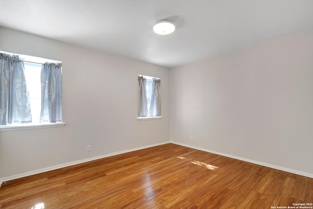 unfurnished room featuring light wood-type flooring and baseboards