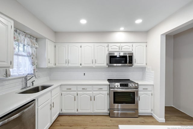 kitchen featuring a sink, light countertops, light wood finished floors, and stainless steel appliances