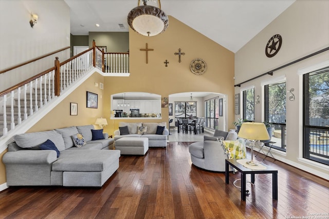 living room with dark wood finished floors, stairs, baseboards, and arched walkways