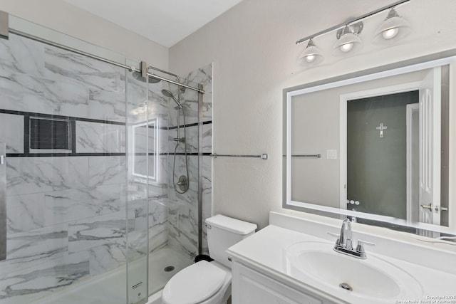 bathroom with a marble finish shower, toilet, vanity, and a textured wall