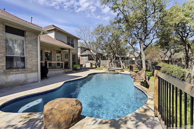 view of swimming pool with a patio, a fenced backyard, and a pool with connected hot tub