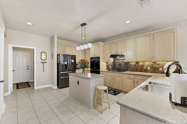 kitchen with visible vents, black appliances, light brown cabinets, a sink, and under cabinet range hood