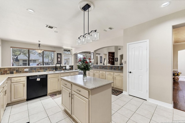 kitchen with visible vents, a sink, a kitchen island, light tile patterned flooring, and dishwasher