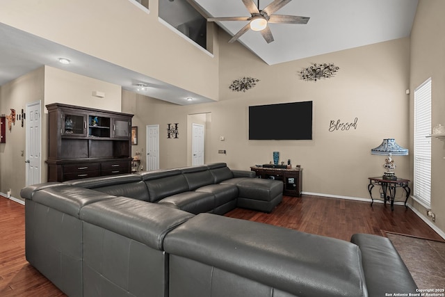 living room featuring dark wood finished floors, a high ceiling, baseboards, and ceiling fan