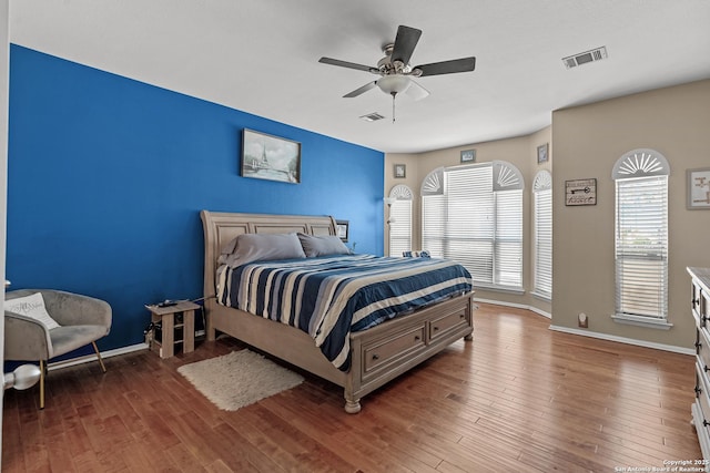 bedroom with visible vents, a ceiling fan, and wood finished floors