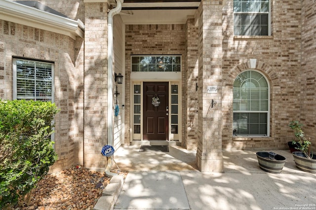 property entrance featuring brick siding