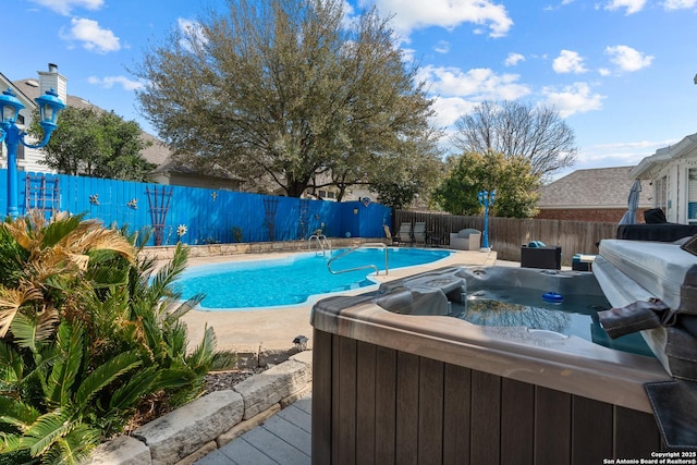 view of swimming pool with a fenced in pool, a fenced backyard, and a hot tub