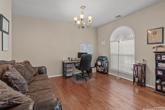 office area with visible vents, baseboards, an inviting chandelier, and wood finished floors