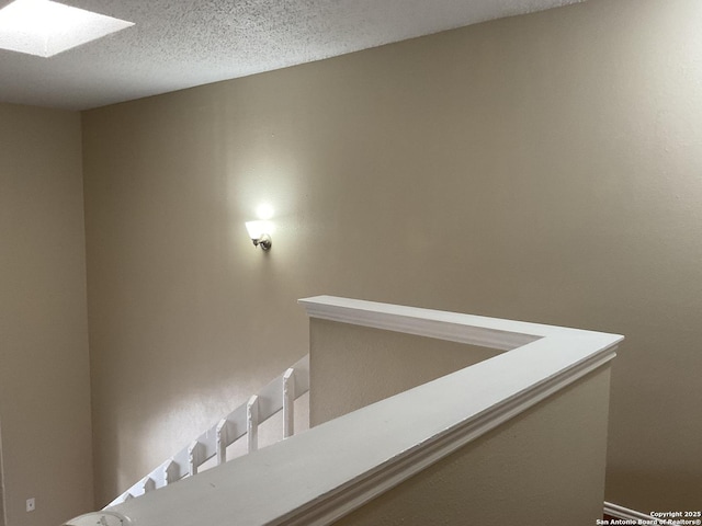 corridor featuring a textured ceiling and a skylight