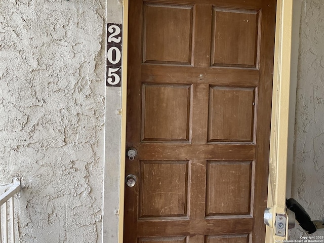 property entrance with stucco siding