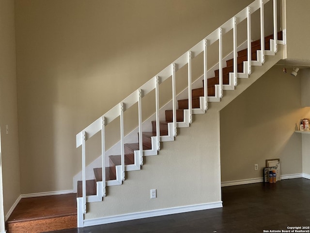 staircase with wood finished floors and baseboards