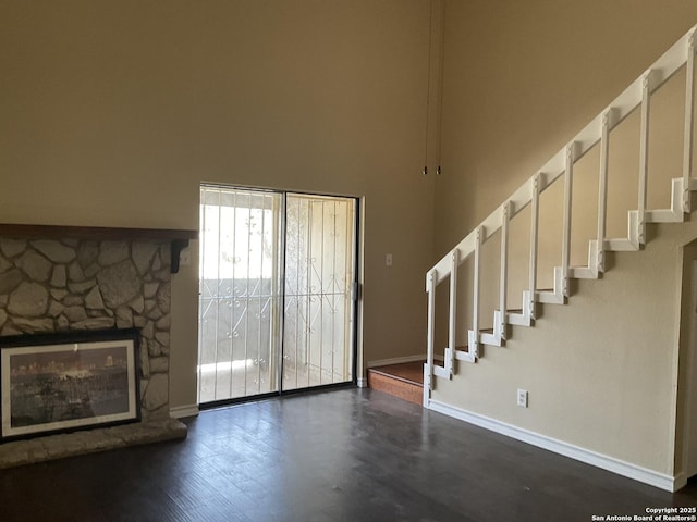 foyer entrance with stairway, a fireplace, and baseboards