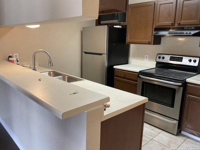 kitchen with under cabinet range hood, a sink, stainless steel appliances, light countertops, and light tile patterned floors