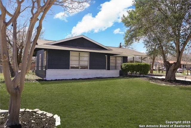 rear view of property featuring a lawn