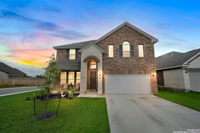 view of front facade featuring a front yard, driveway, stone siding, a garage, and brick siding