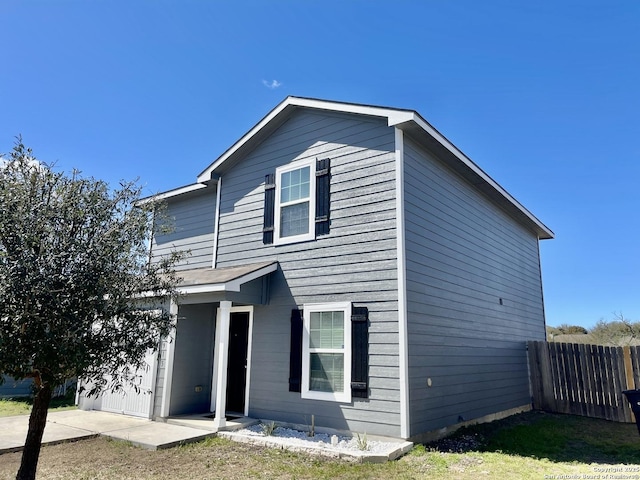 view of front of house with a garage and fence