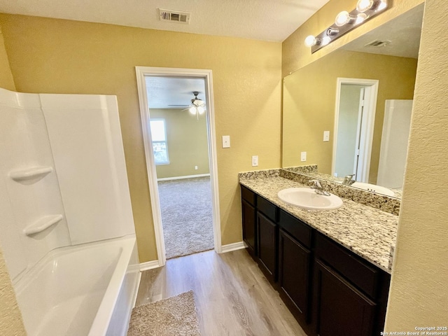 full bathroom with visible vents, wood finished floors, baseboards, ceiling fan, and vanity