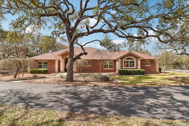 single story home with a front lawn and brick siding