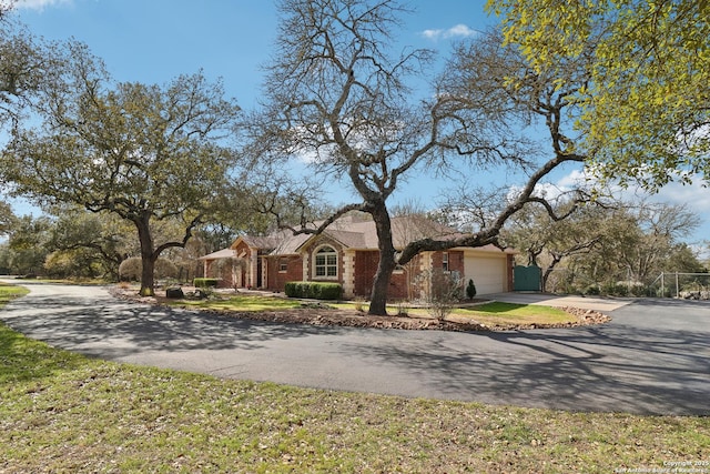 view of front of house with aphalt driveway, brick siding, and a garage