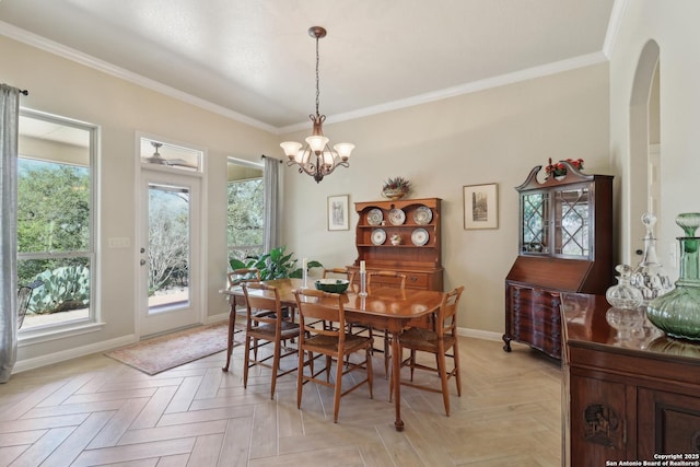 dining space featuring an inviting chandelier, baseboards, and ornamental molding