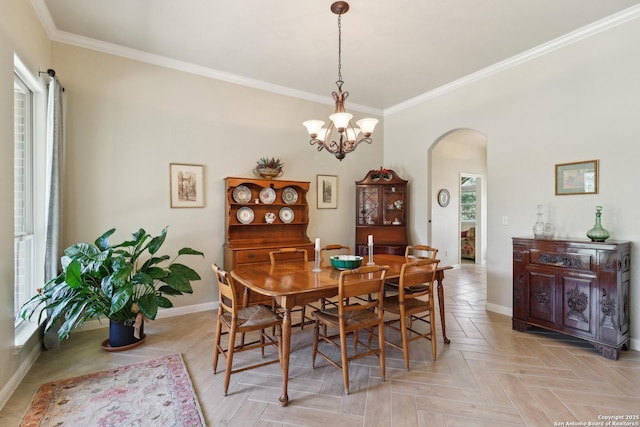 dining room with baseboards, arched walkways, ornamental molding, and a chandelier