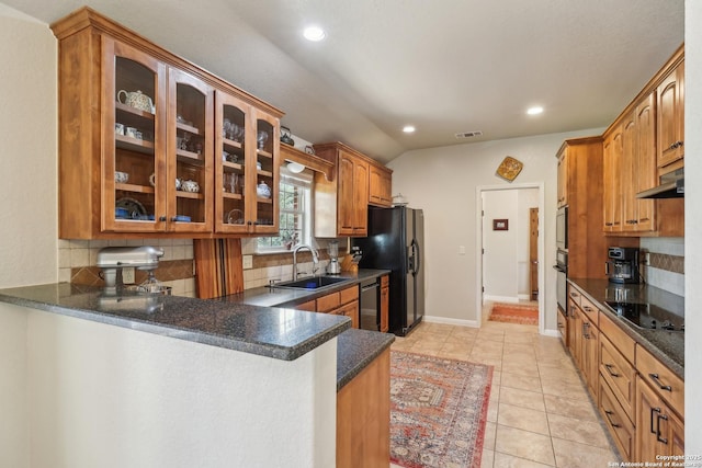 kitchen with a sink, glass insert cabinets, black appliances, and under cabinet range hood