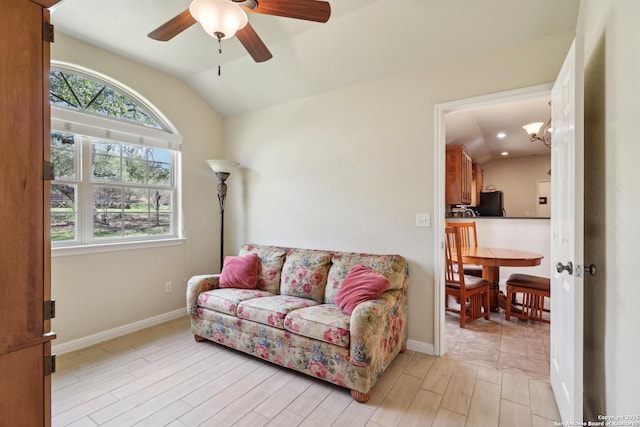 living room featuring baseboards, light wood-style flooring, a ceiling fan, and lofted ceiling