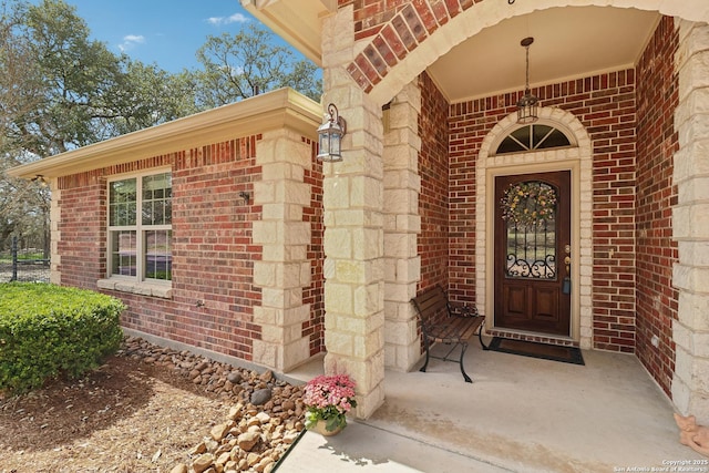 view of exterior entry featuring brick siding