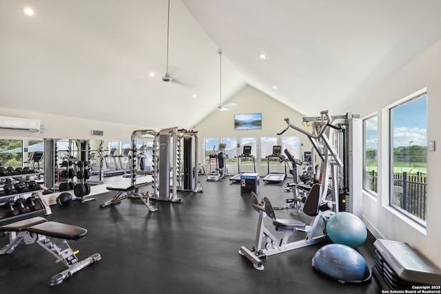 gym with a wealth of natural light, high vaulted ceiling, an AC wall unit, and ceiling fan