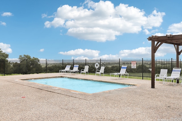 community pool with a patio area and fence