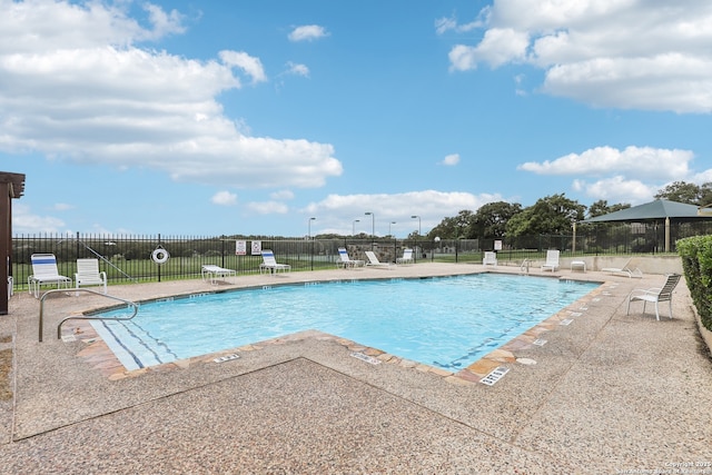 community pool with fence and a patio area