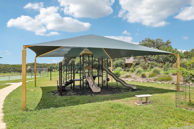 community jungle gym with a yard and fence