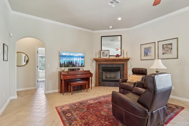 living area featuring a fireplace, arched walkways, visible vents, and baseboards