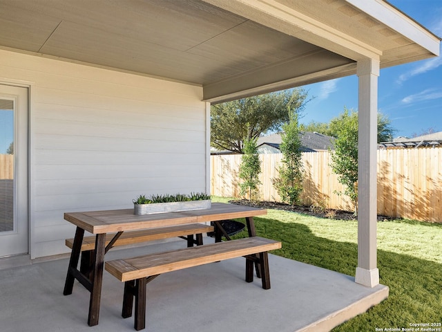 view of patio with outdoor dining space and fence