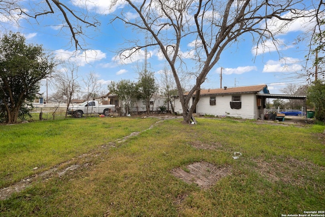 view of yard featuring an attached carport and fence