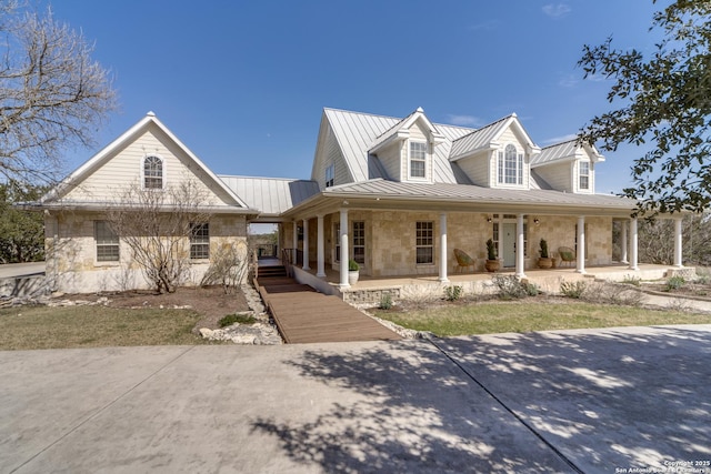 view of front of house featuring metal roof, stone siding, and a standing seam roof